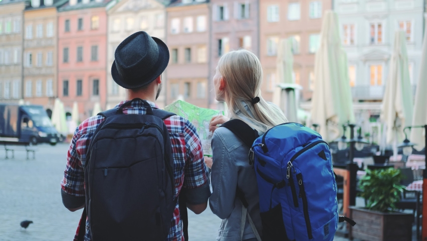 Back view of man and woman with bags checking map on central city square. They discussing their new destination. | Shutterstock HD Video #1069754944