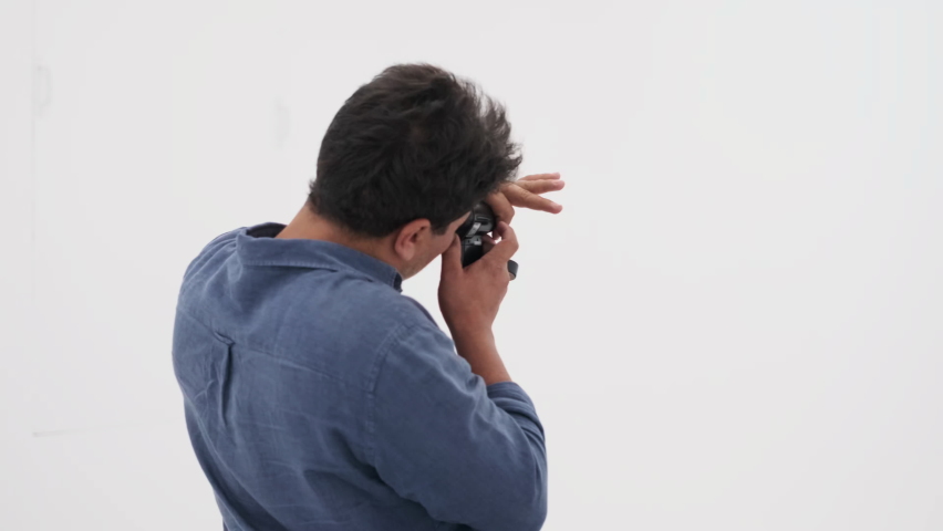 Photographer in denim shirt checking up the light with light meter, slow motion