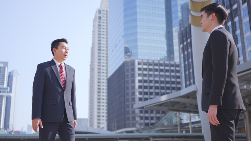 Asian businessman making handshake in the city building in the background. A partnership agreement is successful after complete the negotiation. Business deal, merger and acquisition concepts. Royalty-Free Stock Footage #1069760386