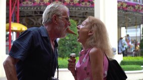 Happy senior couple eating ice cream and dancing together  at the amusement park outdoors in summer.  crazy old man and funny mature woman  having fun in vacation - Powered by Shutterstock - Get 15% off with code: PIKWIZARD15