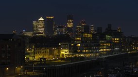 Revealing Establishing Aerial View Shot of London UK, Canary Wharf, Business District, United Kingdom at night evening