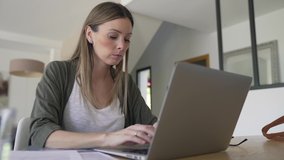 Woman with eyeglasses working on laptop computer from home