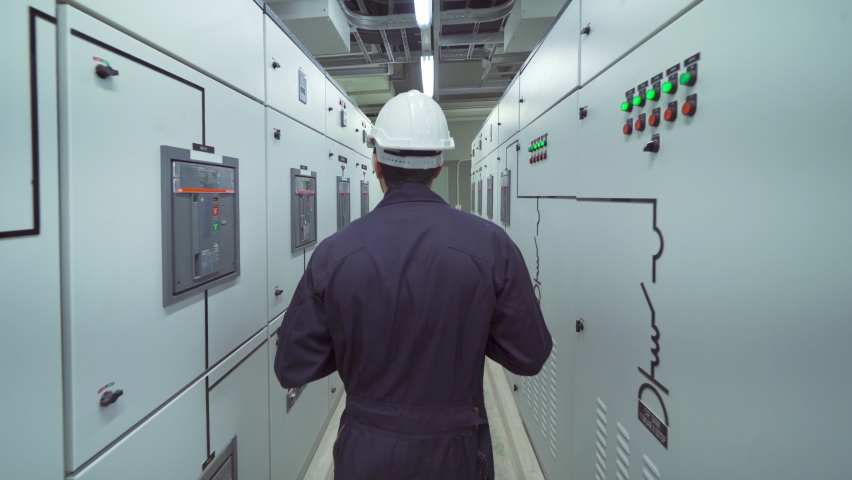 An engineer man or worker, people working in electrical room. Power energy motor machinery cabinets in control or server room, operator station network and circuit center in industry factory system. | Shutterstock HD Video #1069765765