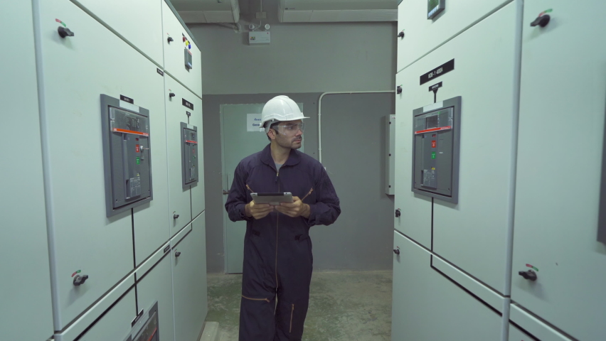 An engineer man or worker, people working in electrical room. Power energy motor machinery cabinets in control or server room, operator station network and circuit center in industry factory system. Royalty-Free Stock Footage #1069765768