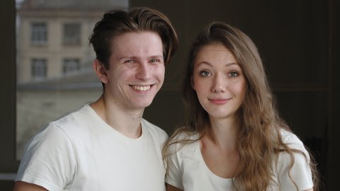 Caucasian newlywed couple friends family boyfriend and girlfriend, husband and wife, man and girl woman questioningly looking at camera asking feeling confused misunderstanding smile, guy winks eye