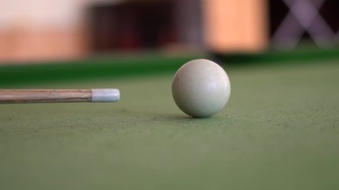 Closeup slow motion shot of cue shooting snooker ball on the snooker table.