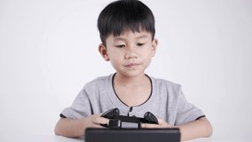 Asian boy about 5 years old using a wireless controller for playing a video game