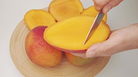 Man cutting mango fruit, Tasty juicy ripe mango cut in cubes with knife. Tropical fruit. How to cut mango video tutorial. eating healthy concept. Mango Macro camera moving