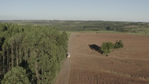 Aerial footage of truck driving on dirt road during the day. Pratânia, Sao Paulo countryside.