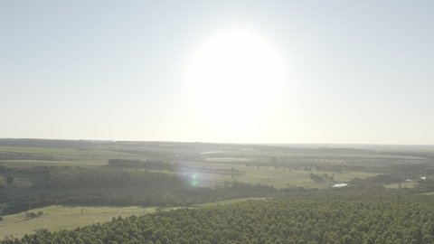 Aerial footage with drone rising revealing rural area during the day. Pratânia, Sao Paulo countryside.