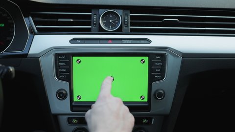 Shot for animation. Finger tapping greenscreen mock-up dashboard screen in modern car. Map application online. Businessman driving luxury car. Business people lifestyle. Weekend trip