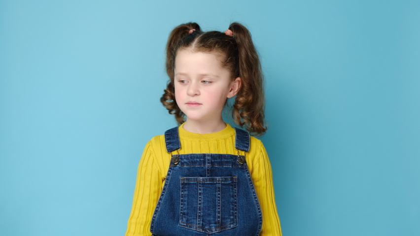 Portrait of funny little preschool girl make gesture raises finger came up with creative plan feels excited with good idea, inspiration motivation, isolated on blue background. Work eureka concept Royalty-Free Stock Footage #1069791628