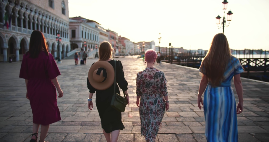 Girl power concept. Camera follows four young happy diverse women walk posing along summer sunrise Venice pier square. | Shutterstock HD Video #1069795636