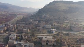 Drone video of an abandoned village in the mountains. Destroyed houses in which no one lives a church, which stand on a hillside in a beautiful landscape. Aerial view Turkey.