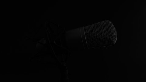 Professional studio microphone on an anti vibration stand being side lit.