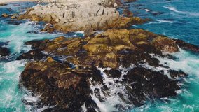 Aerial drone shot over the Chilean coast, cinematic and static stabilized video over the waves hitting the rocks aerial video and travel concept