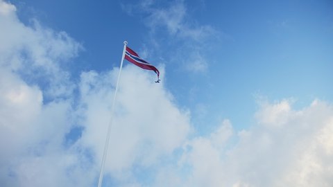 Norwegian flag, winter clouds in Aalesund, Norway.