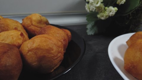 Traditional Bulgarian breakfast made of kneaded dough. Served on a white and black plate. Kokedama from Kalanchoe in the background. Dolly slider shot.