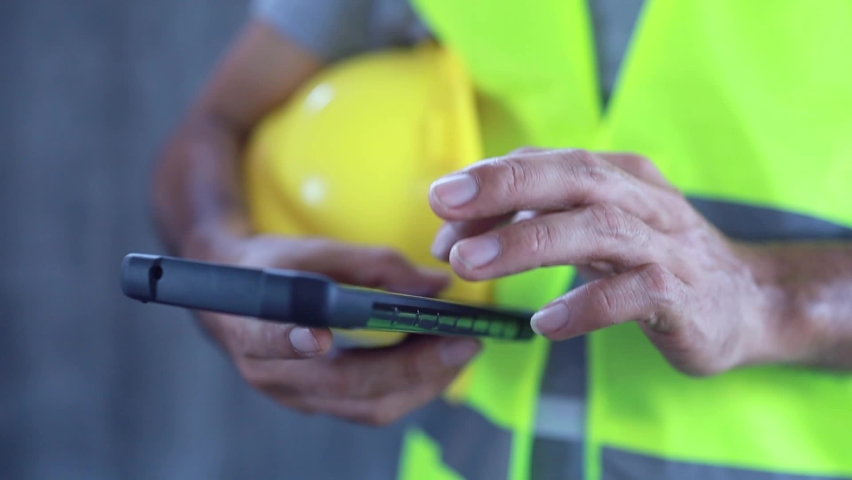 Close up construction workers using smartphone and holding blueprint Royalty-Free Stock Footage #1069810777
