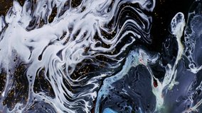drop of white paint spreads through the veins and covers it with a wave on a golden shimmering background. Fluid art. Liquid abstractions. Deep ink spaces. Moving abstract colorful background.