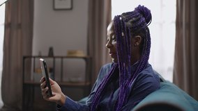 afro-american woman is smiling broadly when communicating by video chat with friend or boyfriend, portrait of black lady indoor