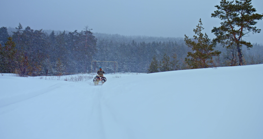 Husky sled carrying a man musher in a sleigh, dog racing. Huskies run fast in competitions, dog sport. Snow is falling, beautiful winter landscape. 4k, ProRes