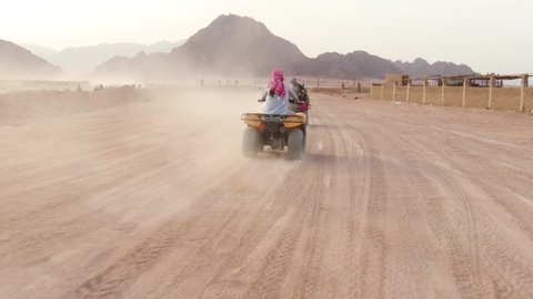Quad bike ride through the desert near Sharm el Sheikh, Egypt.Adventures of desert off-road on ATV .Sand and Sand Borkhan. Rock and sunset. Quad Cycle Travel. Excursion with people.