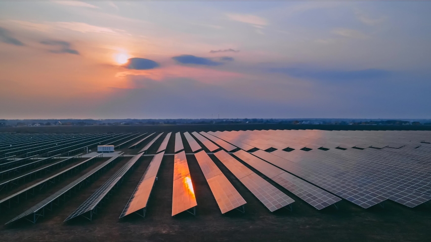 Timelapse aerial drone view of large solar panels at a solar farm at early spring sunset, sun in the sky with clouds. Solar cell power plants. footage video 4k. Green energy innovation concept. Royalty-Free Stock Footage #1069823911