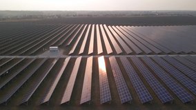 Aerial drone view looking downwards into large solar panels at a solar farm at early spring sunset. Solar cell power plants. footage video 4k.