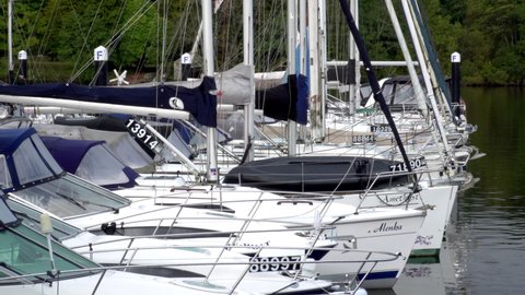 Row of yachts on jetty at Lake Windermere in Cumbria - English Lake District. Focus on line of bows of sailing yachts. Bowness-on-Windermere October 01 2020