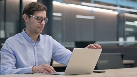 Man in Glasses Closing Laptop and Going Away