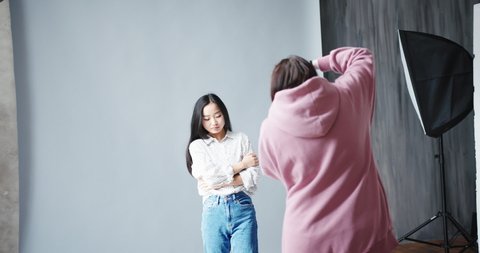 Woman photographer with the professional camera shooting asian korean model Stock Video