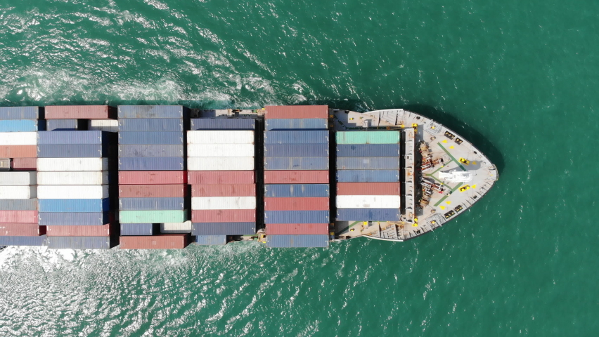 Aerial top view of smart cargo ship carrying container and running very fast for export cargo from container yard port to custom ,Contrail line in the ocean by large ship very fast.  | Shutterstock HD Video #1069843732
