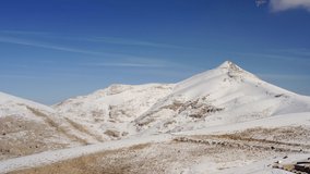 Drone video of snow-capped mountains. Lonely sandy and rocky mountain with a peak covered with snow in winter.Aerial view Turkey.