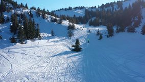 Snowbike riders in mountain valley in beautiful snow powder. Aerial video. Snowdirt bike with splashes and trail. Snowmobile winter sport riding