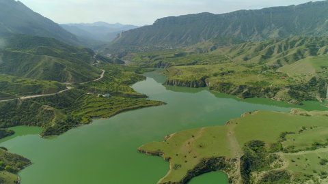 Aerial forward Dagestan Caucasus best nature epic landscape Sulak canyon alpine winding river. Green rugged coast. Serpentine country road. Grand mountains. Open space, horizon. Russia summer travel