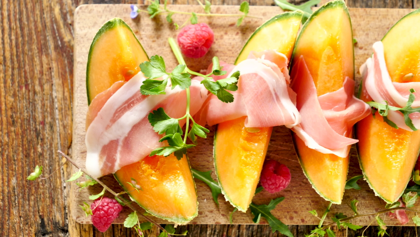 melon slices with prosciutto ham on board