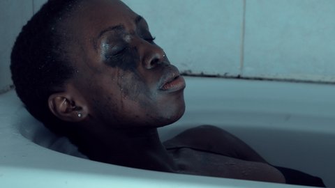 wash the conscience - black woman in the tub stares at camera with guilty look