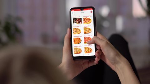 Mobility concept: The girl uses a digitally generated phone with a fast food pizza delivery website on the screen. All on-screen graphics are compiled.