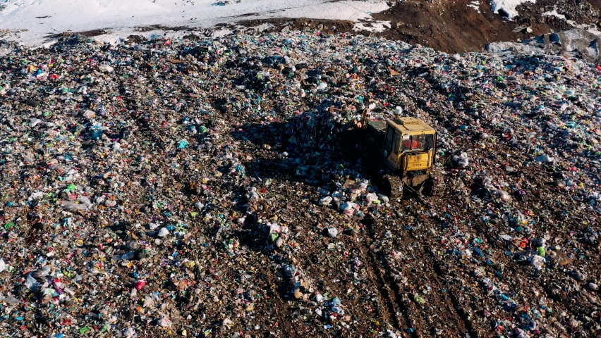 City Dump. The Bulldozer Compacts the Garbage on the Landfill. Birds fly over piles of trash. Wastes of Human Life. Ecology pollution concept. Aerial view | Shutterstock HD Video #1069858324