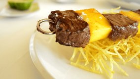 Skewer of mango fruit and meat of cow or beef at grill