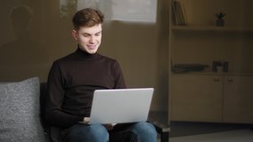 Happy young man millennial user making online call using laptop and modern computer app at home for remote conversation. Caucasian guy teen male student laughing talking to friends on video conference