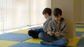 a video of two boys gaming on their phones
