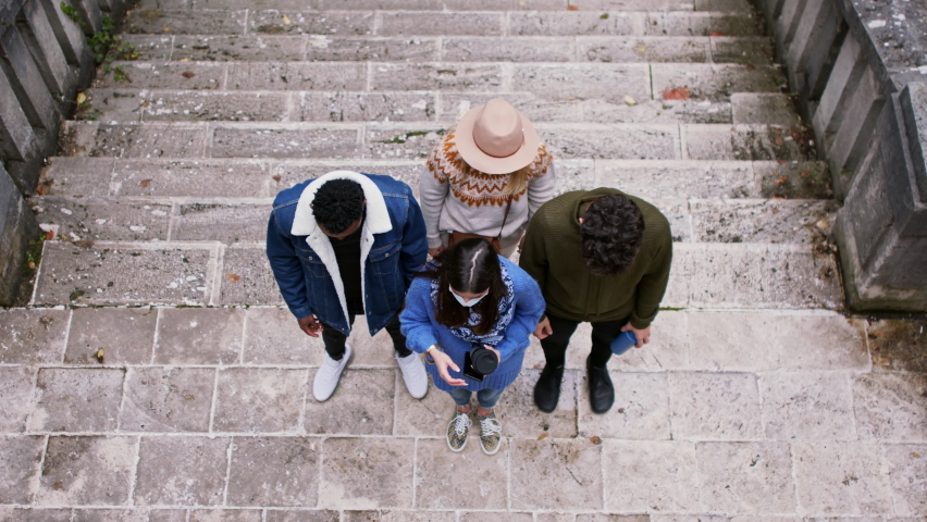 Top view of group of young people outdoors in town, looking at camera. Coronavirus concept.