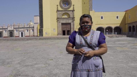 A Hispanic female standing at center of The Convent of San Gabriel Arcangel in Cholula, Mexico