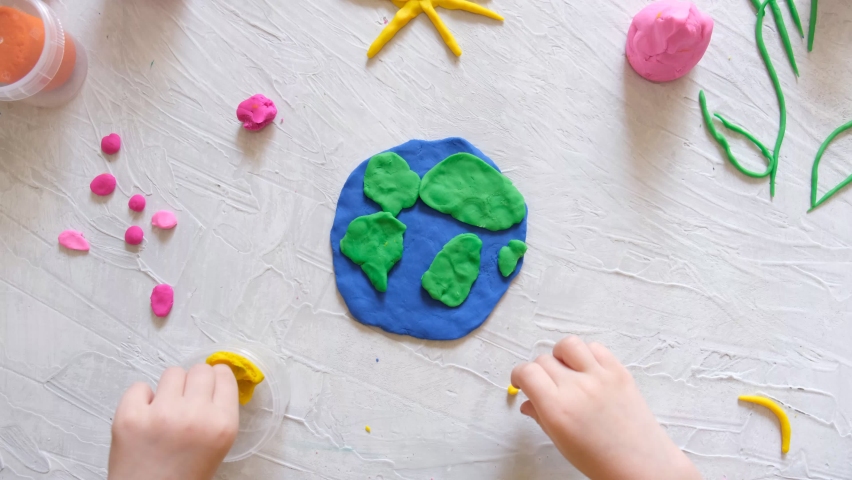 Child sculpturing plasticine planet for earth day. Protection of environment, Save our planet. Ecology concept. Concept of art learning and education, love earth , save world and unity.
 Royalty-Free Stock Footage #1069876372
