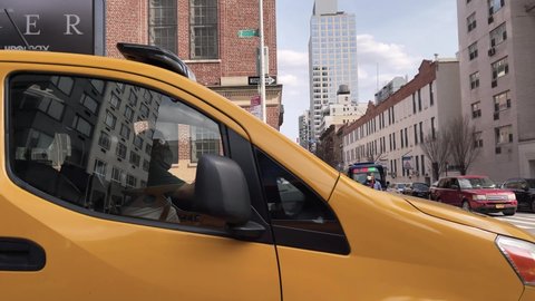 NYC, USA - MARCH 27, 2021: driving past yellow taxi cab caravan with Tiger Woods ad Manhattan New York City.