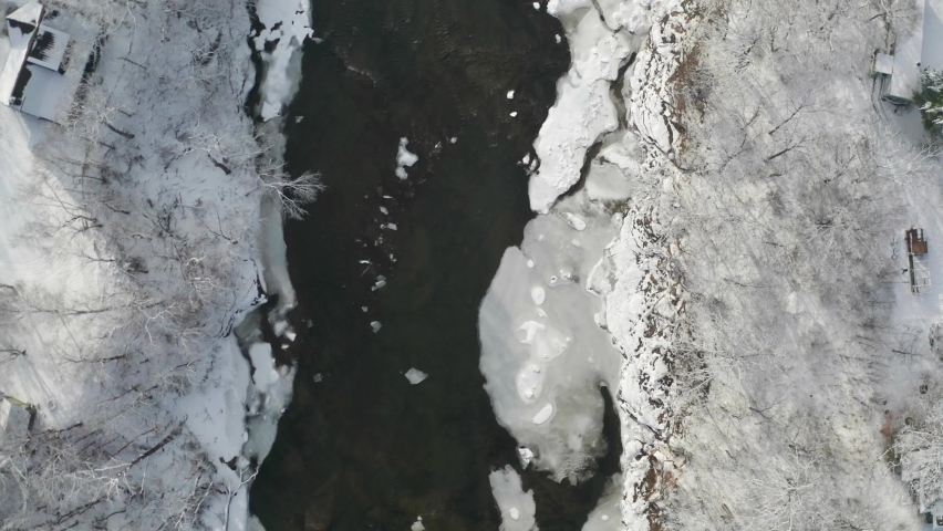 Top-down view of frosty winter river and two-lane bridge. Travel concept