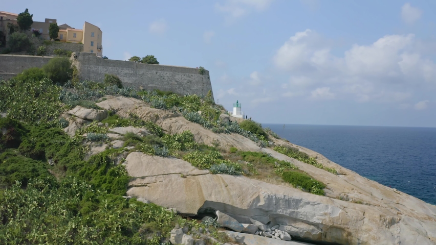 Aerial: Flight over historical citadel of Calvi, beautiful city on Corsica island, France, Europe