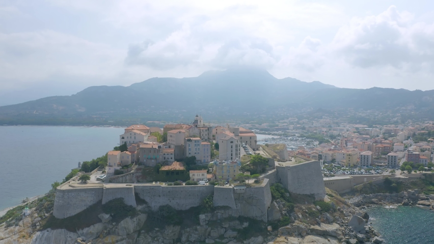 Aerial: Flight over historical citadel of Calvi, beautiful city on Corsica island, France, Europe